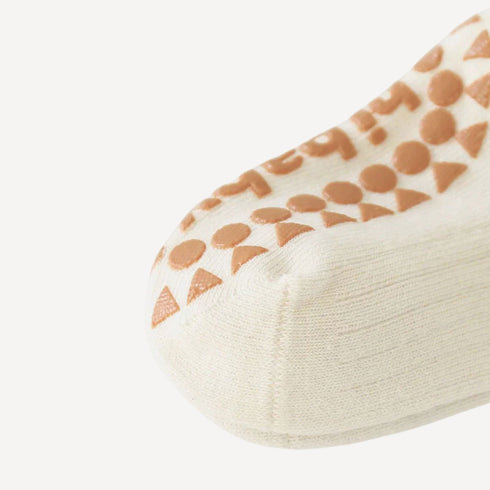Détail des chaussettes antidérapantes bébé, pensées dans les moindres finitions pour allier sécurité, confort et délicatesse.