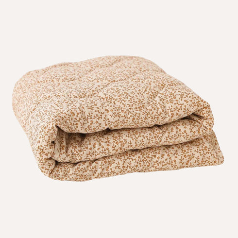 Couette chaude pour lit bébé, conçue pour les nuits fraîches, dans un coloris feuilles d'automne qui apporte confort et douceur à la chambre.