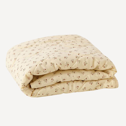 Couette chaude pour lit bébé, en coloris beige doux, ornée d’un motif de fleurs en forme de cœur pour une touche tendre et réconfortante.