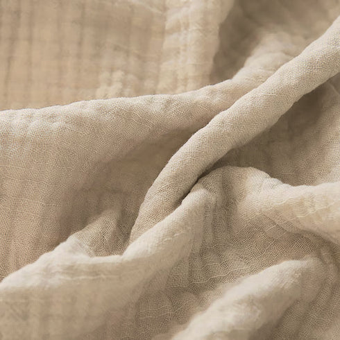 Couverture pour bébé en gaze de coton, dans un coloris kaki, avec de jolis détails visibles en zoom, pour une touche de douceur et d’élégance.