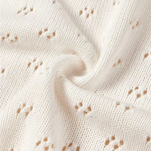 Un zoom sur les motifs de la maille révèle tout le raffinement de notre couverture en tricot pour bébé blanche : un tricot délicat et soigné, signature de la douceur intemporelle de Bellemoon.