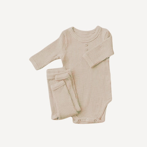 Notre pyjama bébé 2 pièces en coton beige enveloppe les tout-petits de douceur naturelle, dans un esprit minimaliste et élégant propre à l’univers Bellemoon.