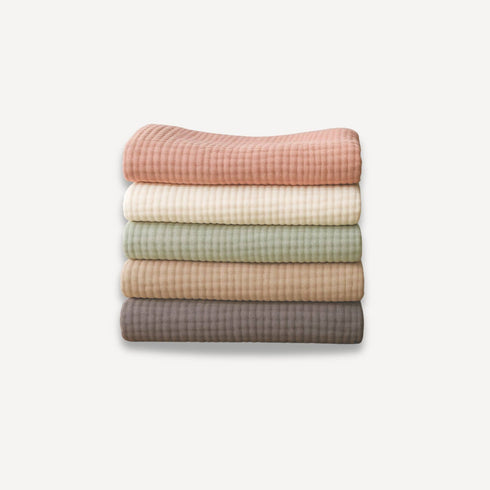 Lot de cinq couvertures pour bébé en gaze de coton, douces et respirantes, avec de belles finitions visibles en détail pour allier confort et élégance au quotidien.