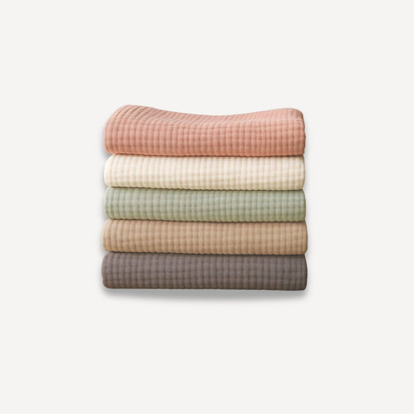 Lot de cinq couvertures pour bébé en gaze de coton, douces et respirantes, avec de belles finitions visibles en détail pour allier confort et élégance au quotidien.