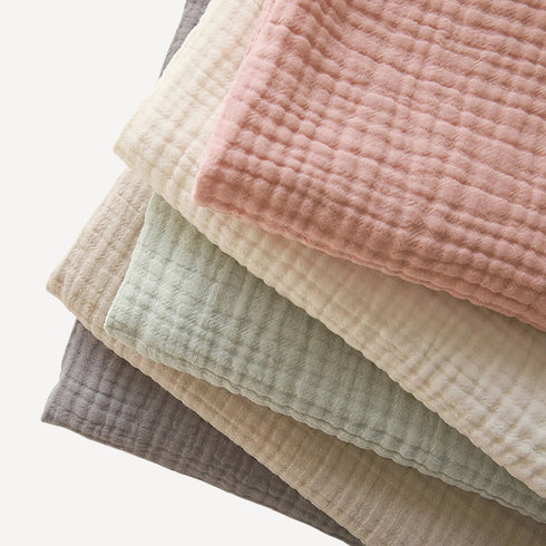 Lot de cinq couvertures pour bébé en gaze de coton, douces et respirantes, avec de belles finitions visibles en détail pour allier confort et élégance au quotidien.