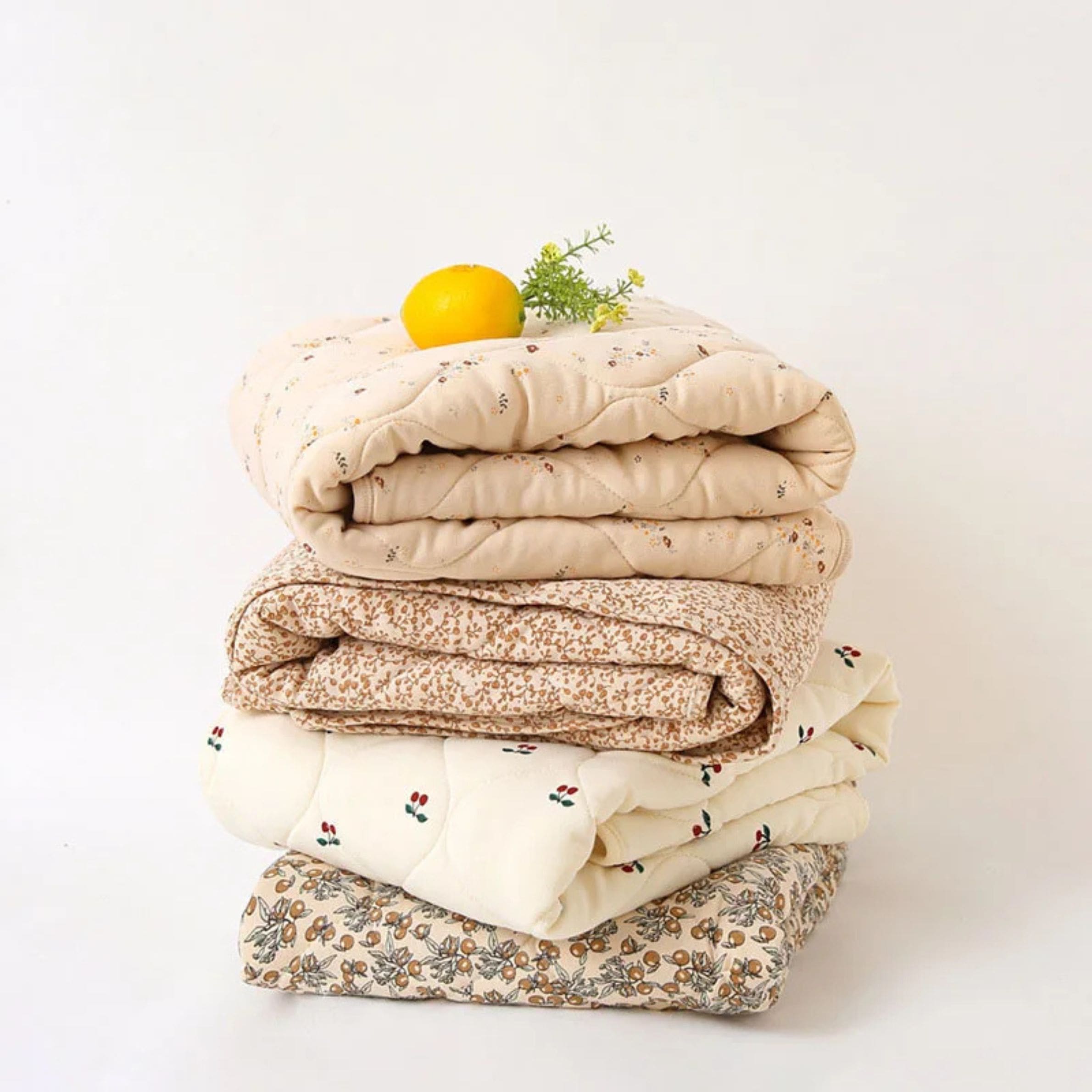 Lot de quatre couettes chaudes pour lit bébé, parfaites pour les nuits fraîches, ornées de motifs à fleurs pour allier confort et charme naturel.