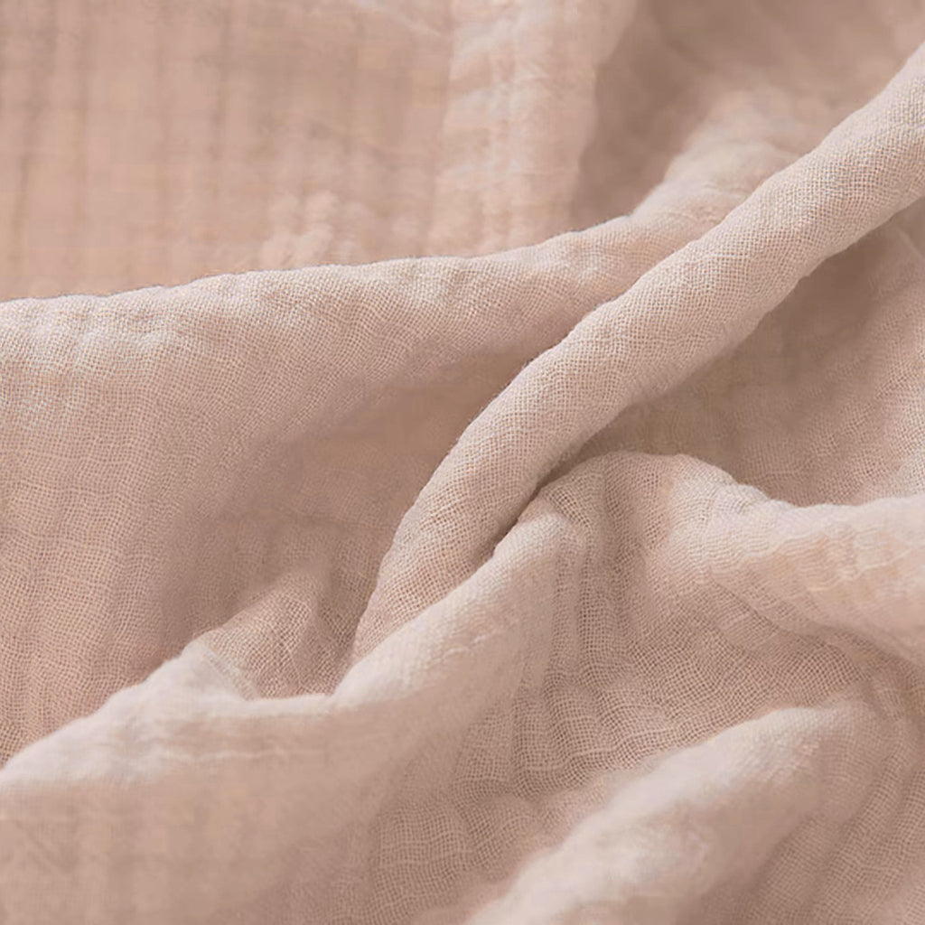 Couverture pour bébé en gaze de coton, dans un coloris rose poudré, ultra douce et respirante pour accompagner chaque saison.