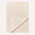 Notre couverture en tricot pour bébé, dans un joli beige naturel, allie chaleur, confort et élégance pour accompagner les premiers instants de votre tout-petit avec tendresse.