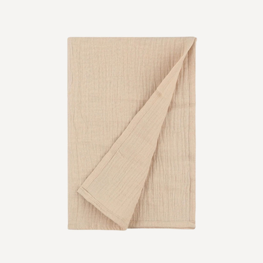 Notre lange pour emmailloter bébé, en beige doux et naturel, crée un cocon de tendresse et de simplicité, en parfaite harmonie avec l’élégance intemporelle de l’univers Bellemoon.