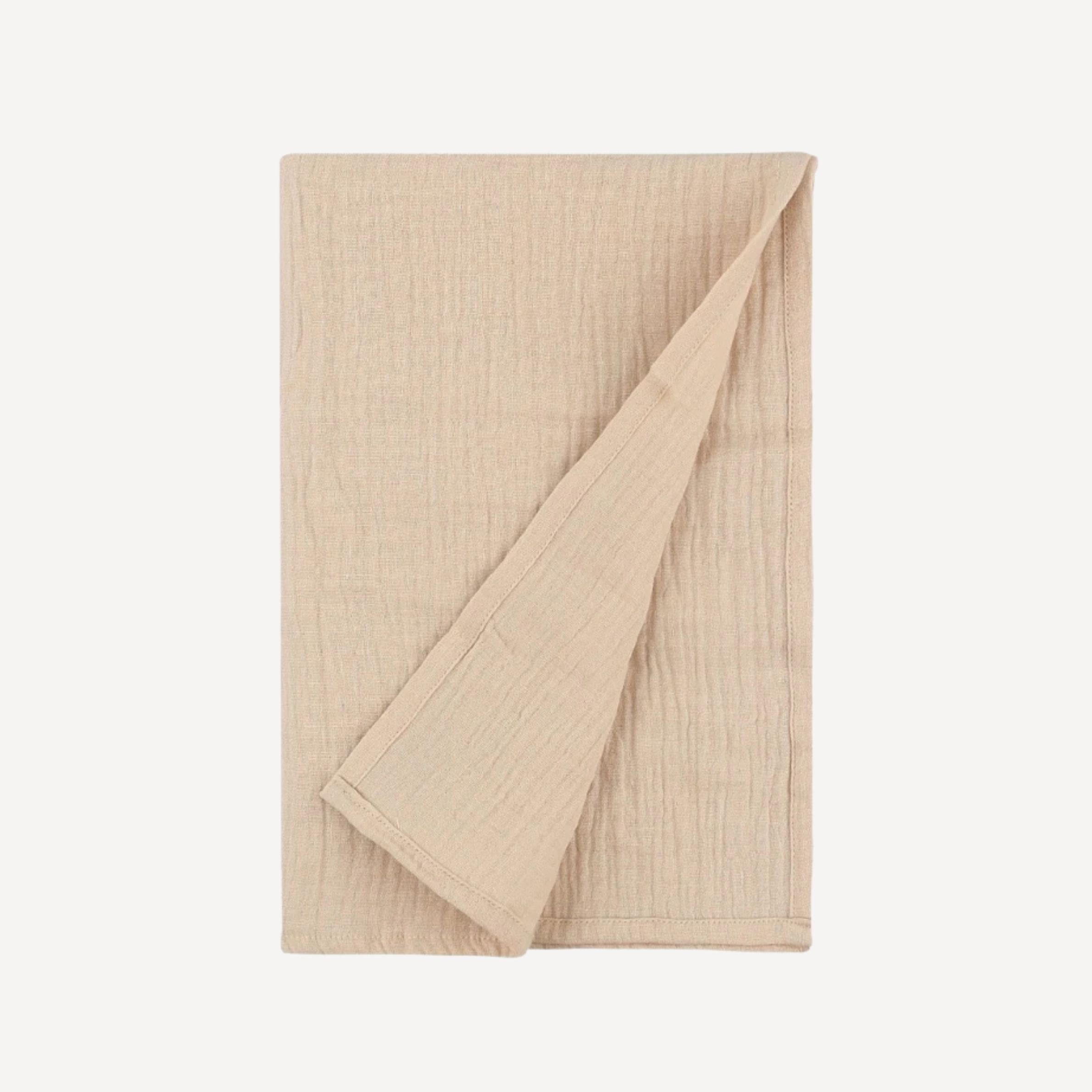 Notre lange pour emmailloter bébé, en beige doux et naturel, crée un cocon de tendresse et de simplicité, en parfaite harmonie avec l’élégance intemporelle de l’univers Bellemoon.