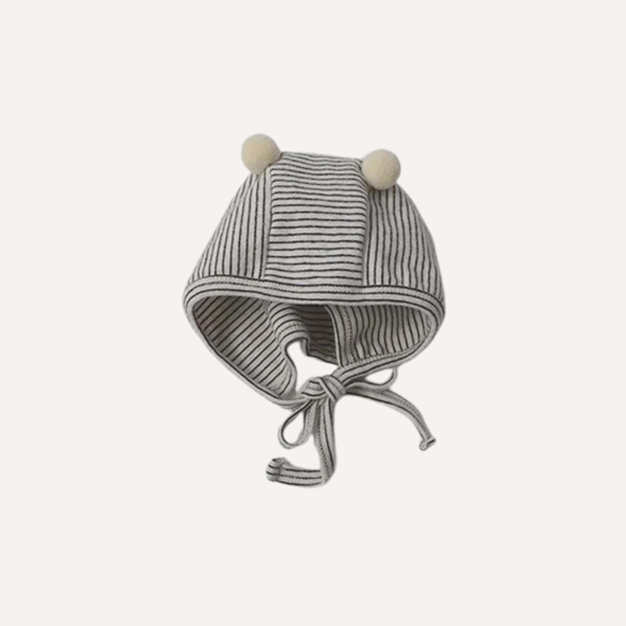 Ce pyjama coton bébé garçon et son bonnet gris enveloppent les premiers sommeils d’une douceur apaisante et intemporelle.