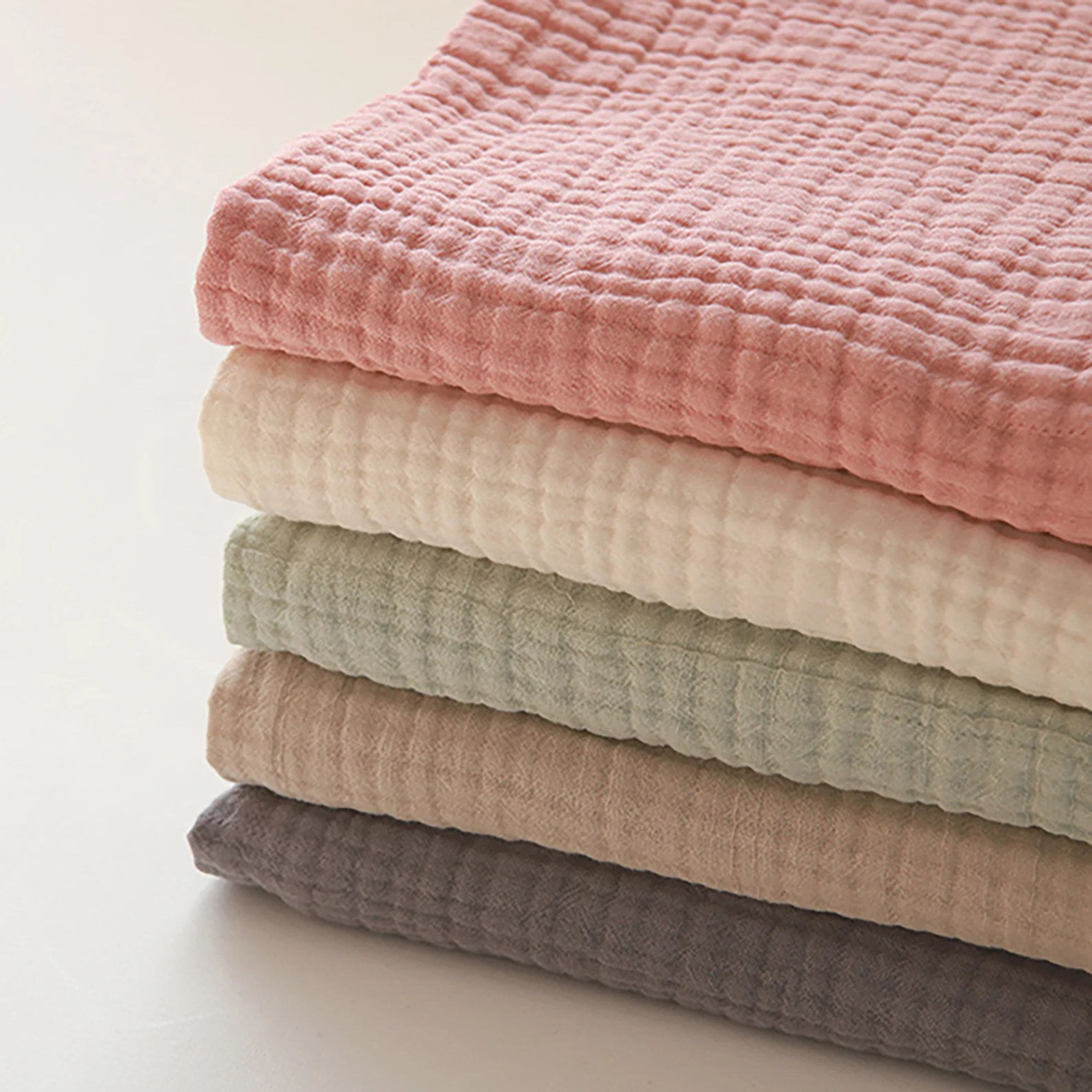 Lot de cinq couvertures pour bébé en gaze de coton, douces et respirantes, pensées pour offrir un maximum de confort avec une touche d’élégance au quotidien.