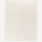 La vue d’ensemble de notre couverture en tricot pour bébé blanche laisse apparaître toute la finesse de sa maille et la pureté de sa teinte, reflet de l’élégance douce et intemporelle propre à l’univers Bellemoon.
